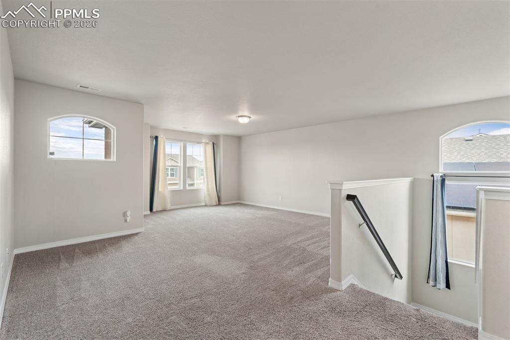Carpeted empty room with baseboards