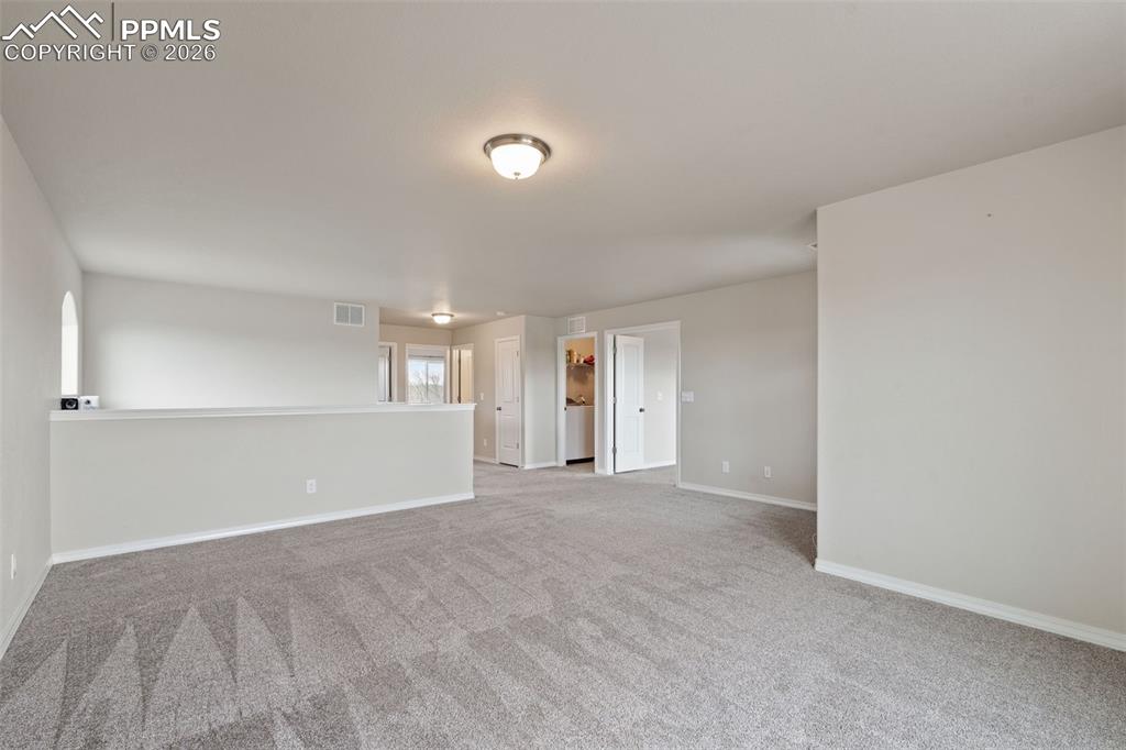 Spare room with baseboards and light colored carpet