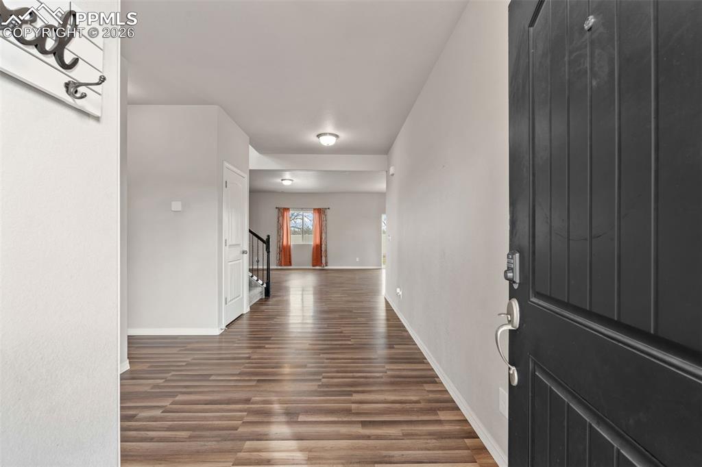 Foyer featuring dark wood-style floors and stairway