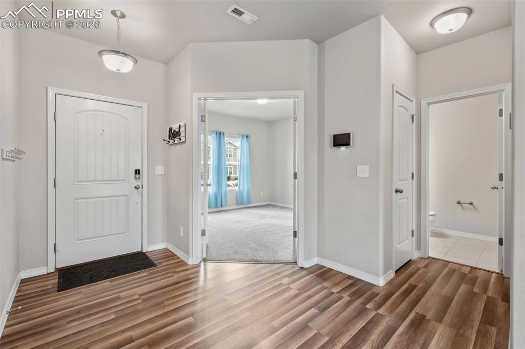 Foyer entrance featuring baseboards and wood finished floors