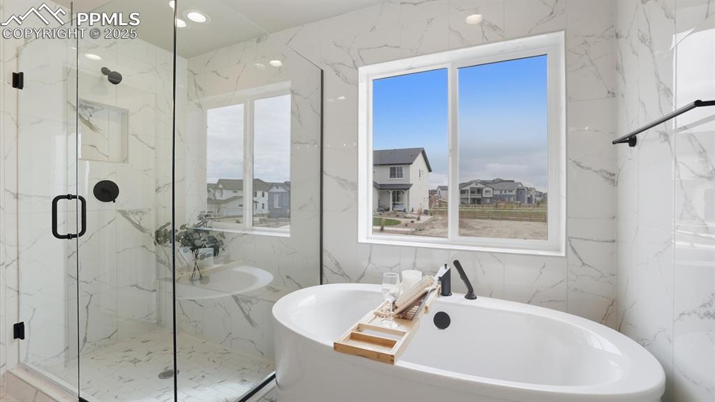 Soaking tub and tiled shower with built-in seat in the Primary Bathroom.