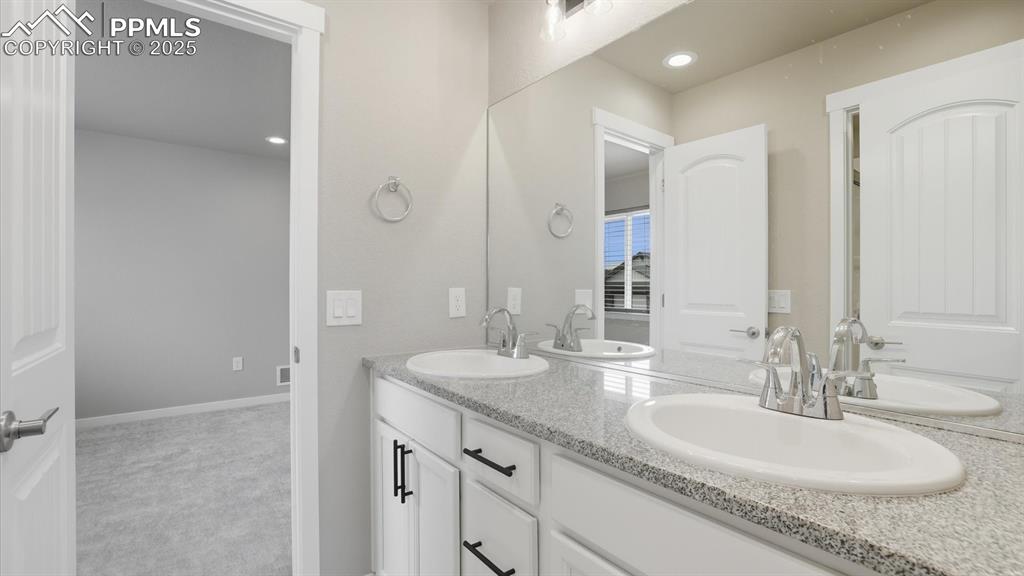 Bedrooms 1 & 2 share a Shower Bathroom with dual sink vanity with quartz countertops, mirror, and enclosed shower.