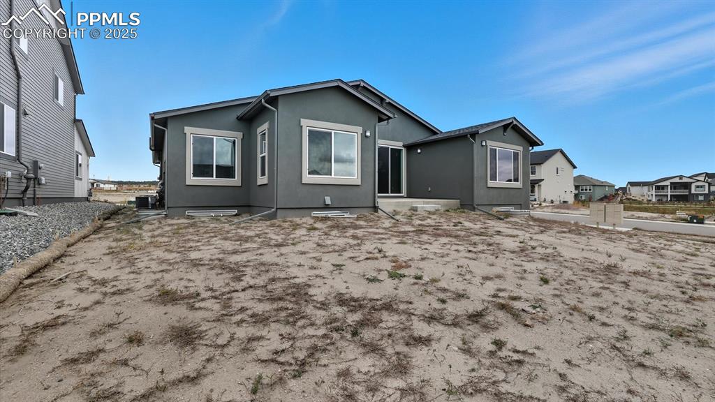 Rear view of home and backyard with concrete patio and gas stub for grill.
