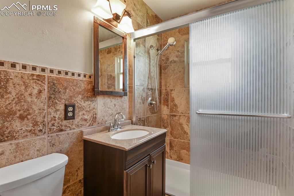 Bathroom with tile walls and vanity