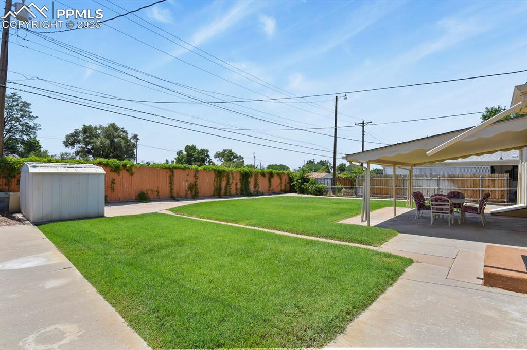 Fenced backyard with a patio and a shed