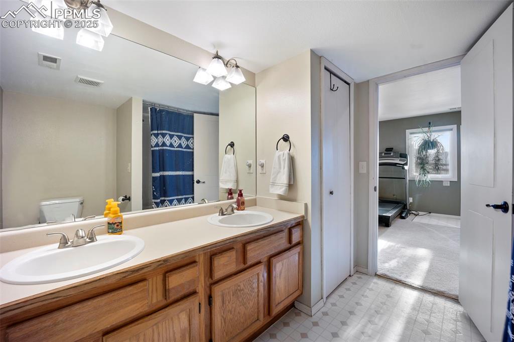 Bathroom featuring visible vents, toilet, and a sink