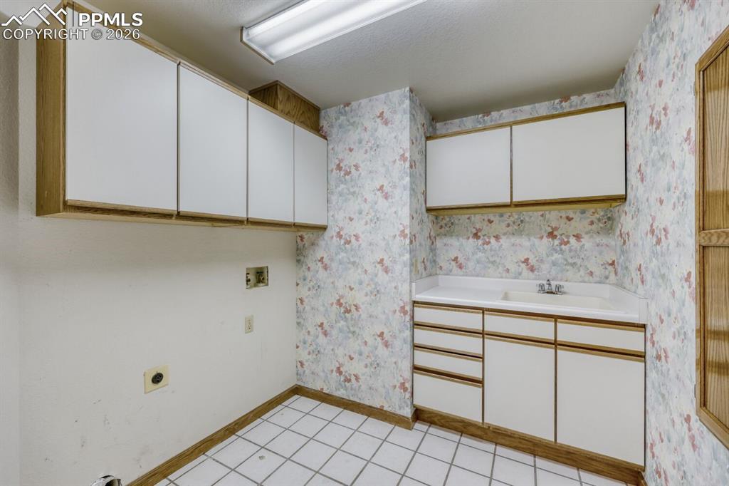 main level laundry with built in ironing board and sink