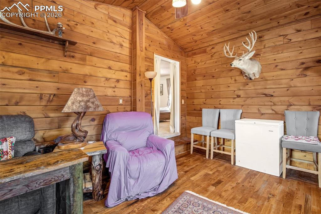 Sitting room off primary with gas burning stove, wood floors and wood accents throughout