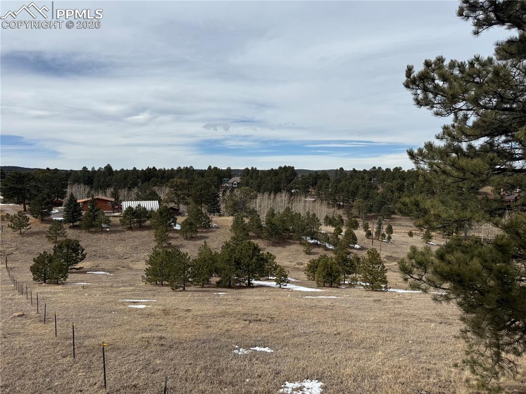 Fenced land with home on the horizon