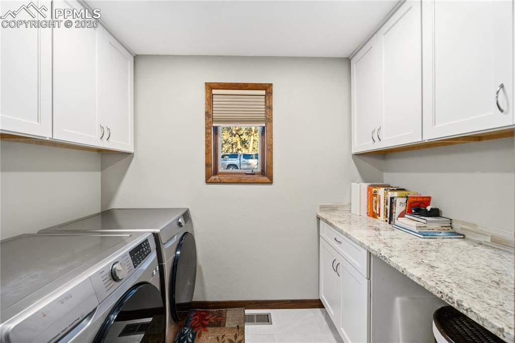 main level laundry room with folding table and cabinets
