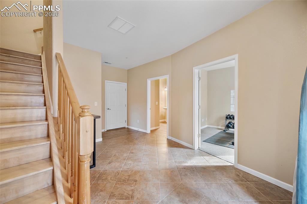 Tiled Enty way and bonus room, bedroom, work out gym, 3/4-bathroom door leading to the garage. Large storage under the staircase. Upgraded wood stairs adding elegance to this beautiful home. Wall was added by owner to create a room. 
