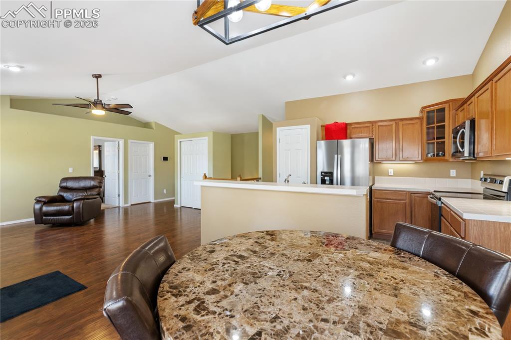 Dining area featuring lofted ceiling, wood finished floors, ceiling fan, and recessed lighting