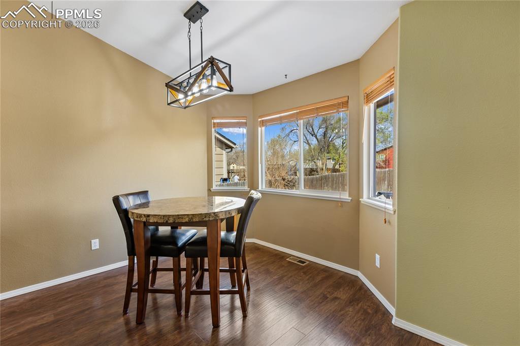 Dining area featuring dark wood-style flooring and plenty of natural light