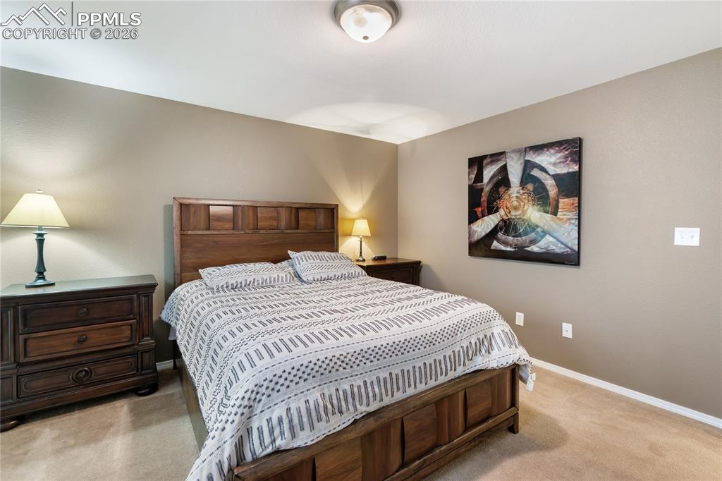 Bedroom featuring light colored carpet and baseboards