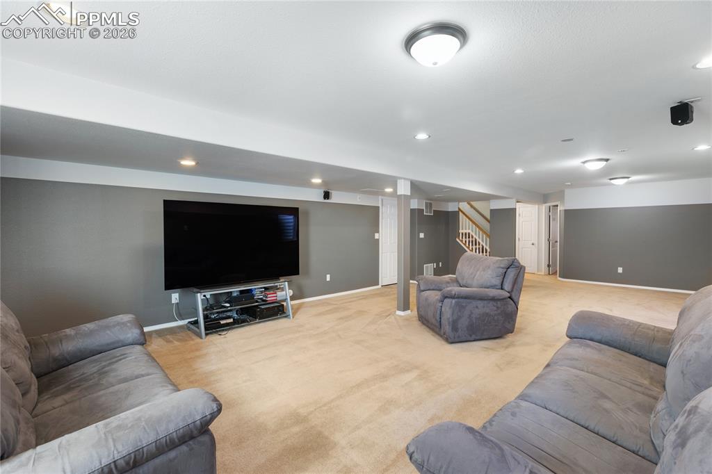 Living room with light colored carpet and recessed lighting