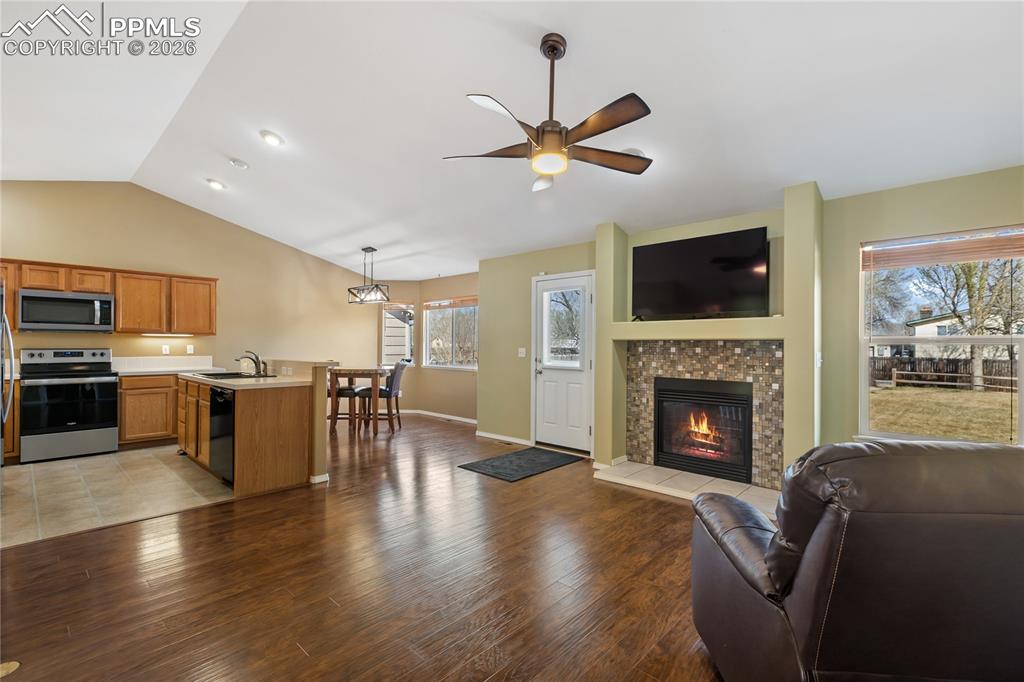 Living area featuring light wood finished floors, a ceiling fan, and a fireplace