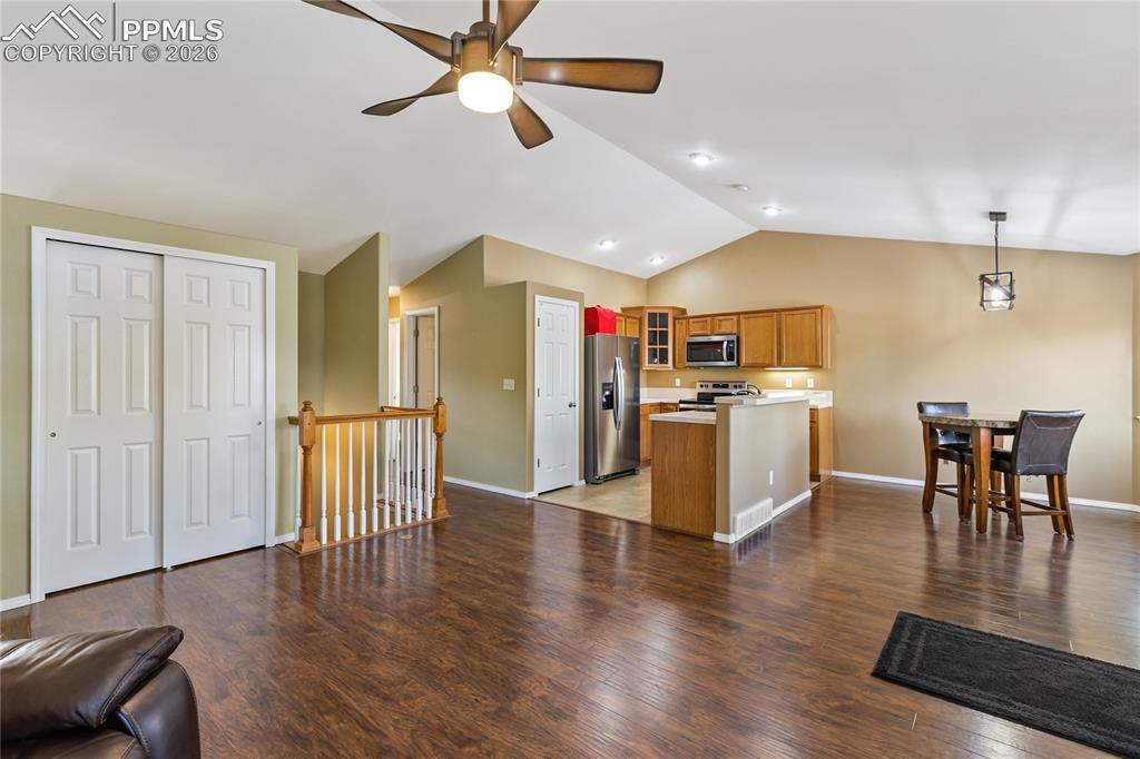 Kitchen featuring open floor plan, glass insert cabinets, wood finish cabinets, and light countertops