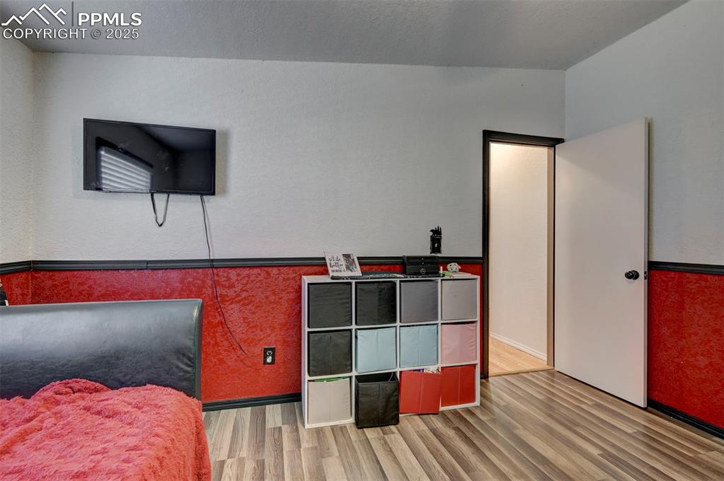 Bedroom with wood finished floors and a textured ceiling