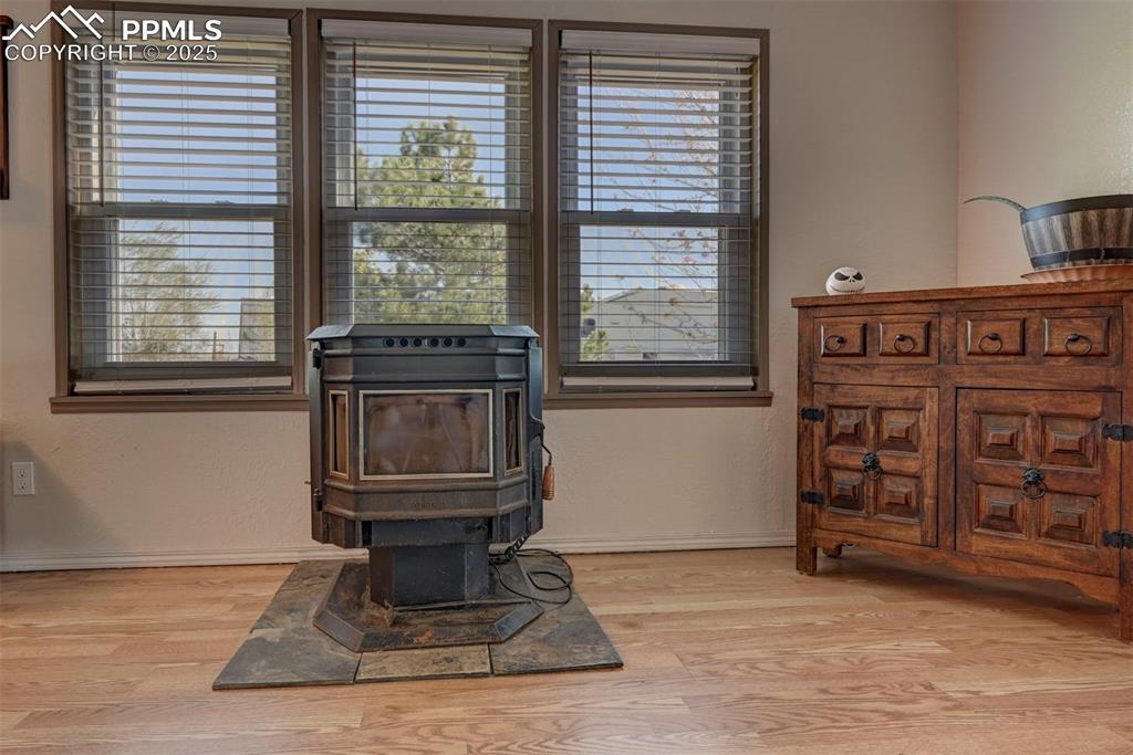 Detailed view of a wood stove, wood finished floors, and a textured wall