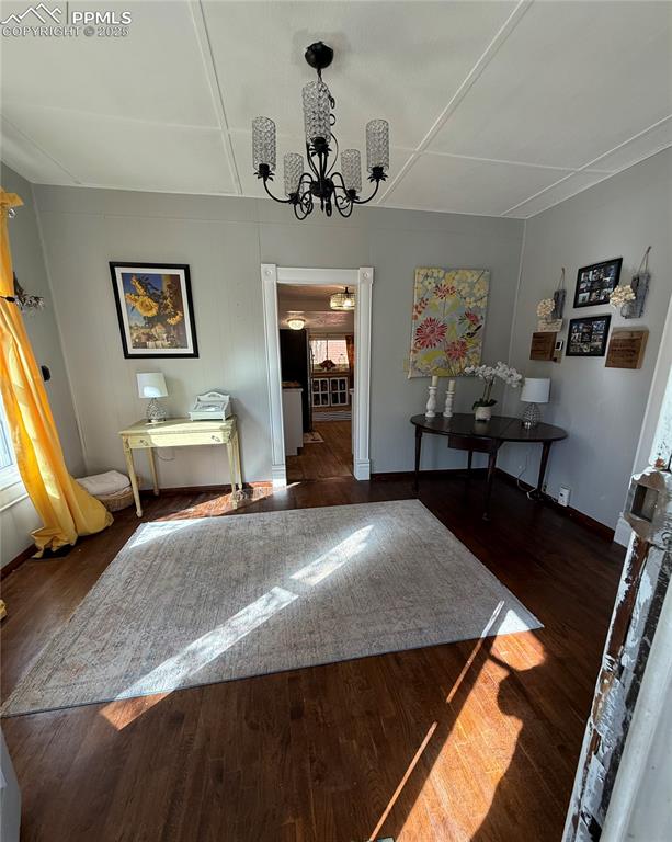 Dining room featuring a chandelier, wood finished floors, and baseboards