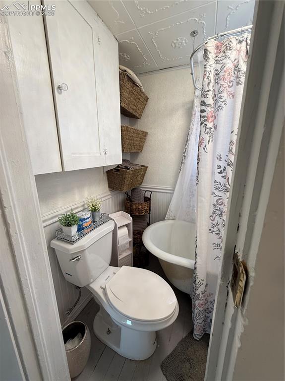 Bathroom with a toilet, and a shower with curtain