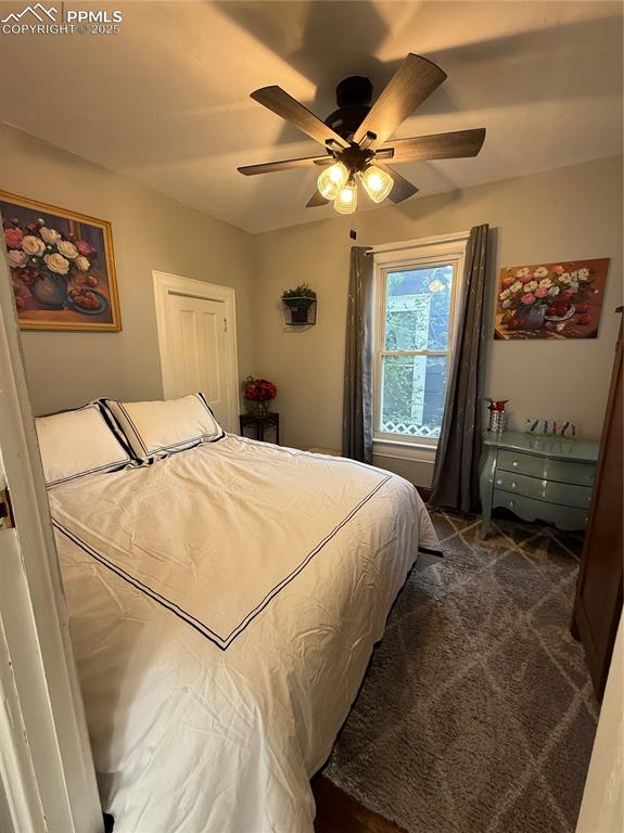 Bedroom featuring dark colored carpet and ceiling fan