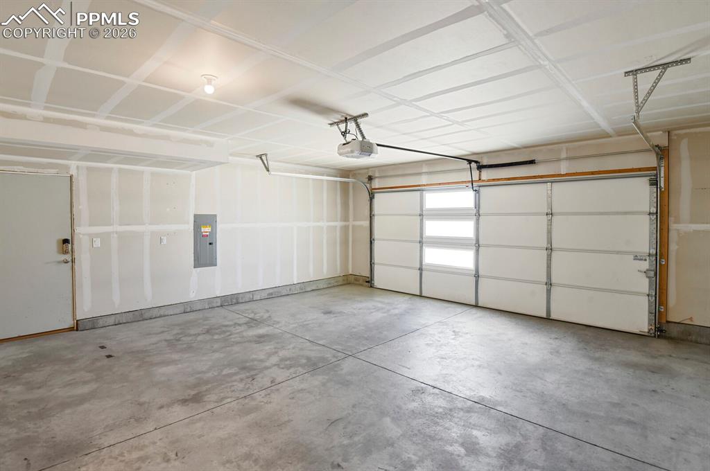 Garage with electric panel and a My Q  garage door opener and service door. 