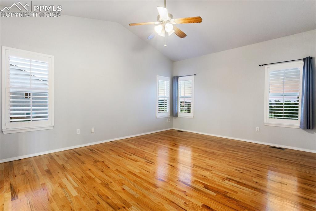 Unfurnished room featuring a ceiling fan, light wood-style floors, and high vaulted ceiling