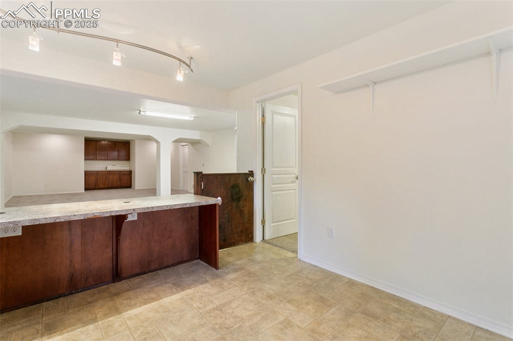 Kitchen featuring arched walkways, light countertops, and a breakfast bar area