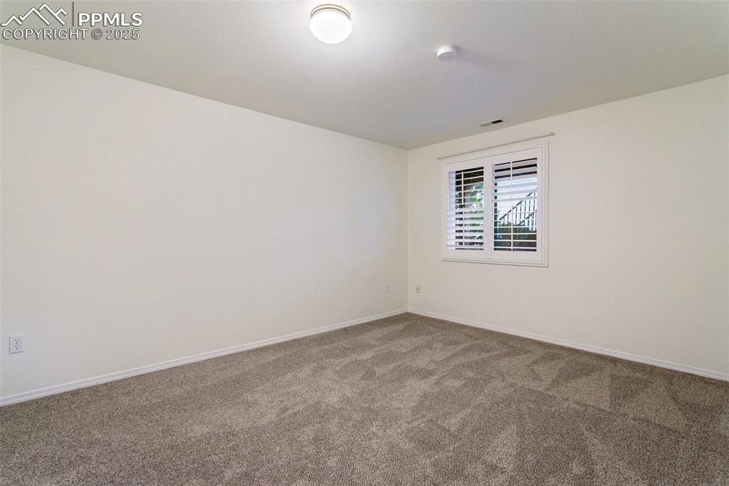 Unfurnished room with carpet flooring and a smoke detector