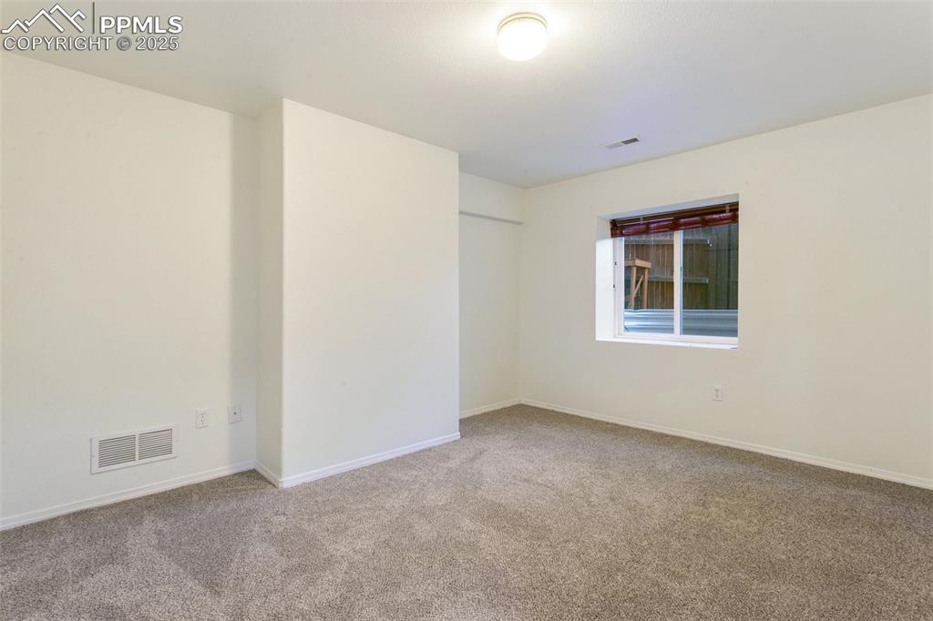 Empty room featuring carpet and baseboards