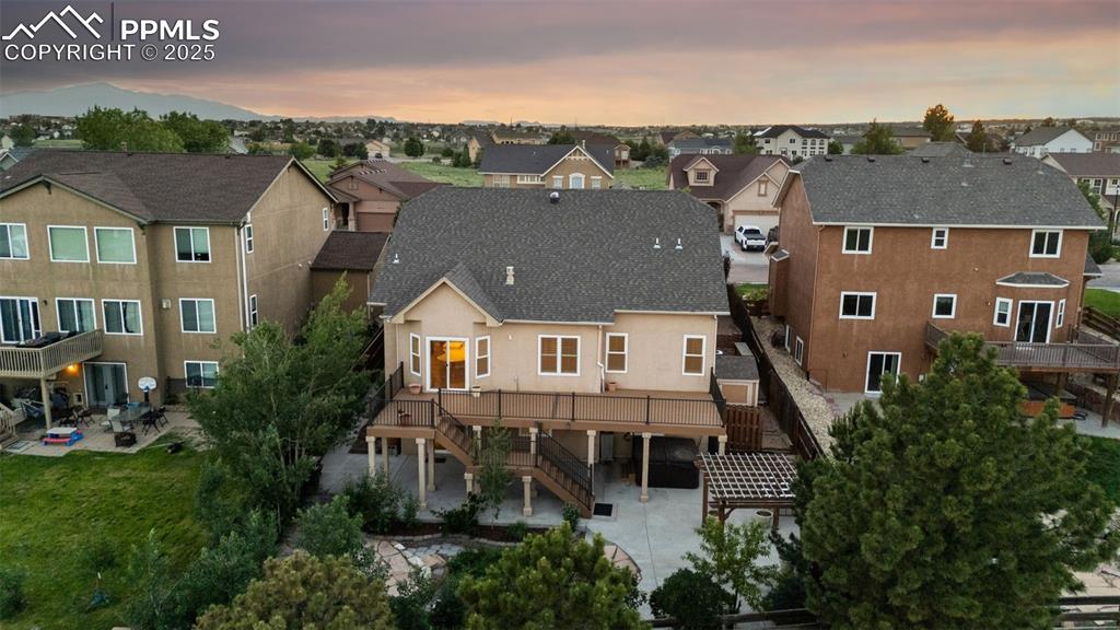 Back of house with stairway, a patio area, and a residential view