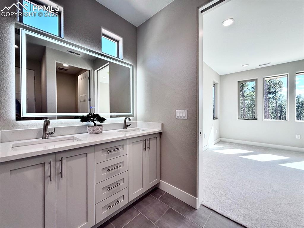 Luxurious Primary Bathroom with Double Vanities, Quartz Countertops, Heated Mirror to avoid fogging, Deep Soaking Tub, Large Shower with Bench and Glass Door.