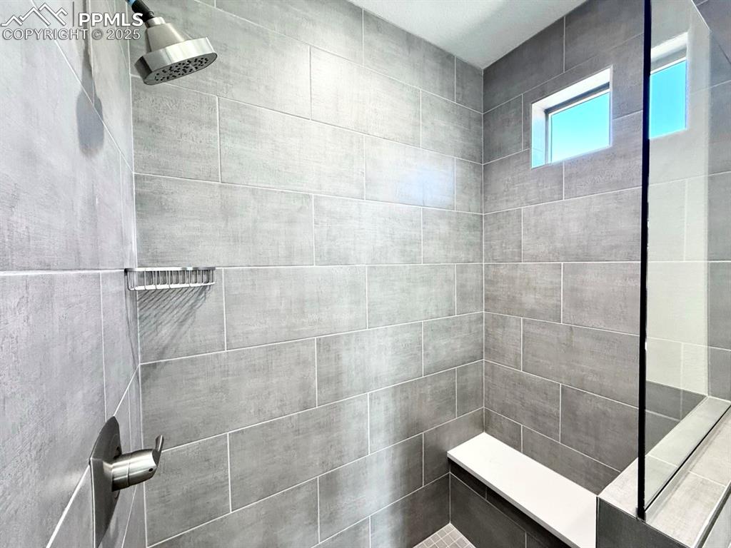 Luxurious Primary Bathroom with Double Vanities, Quartz Countertops, Heated Mirror to avoid fogging, Deep Soaking Tub, Large Shower with Bench and Glass Door.