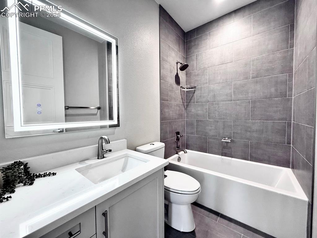 Full Bathroom with Deep Soaking Tub and Shower tiled to the ceiling. Quartz Countertop and a Heated Mirror to avoid fogging.