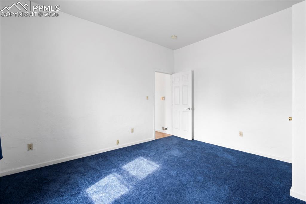Spare room featuring baseboards and carpet flooring