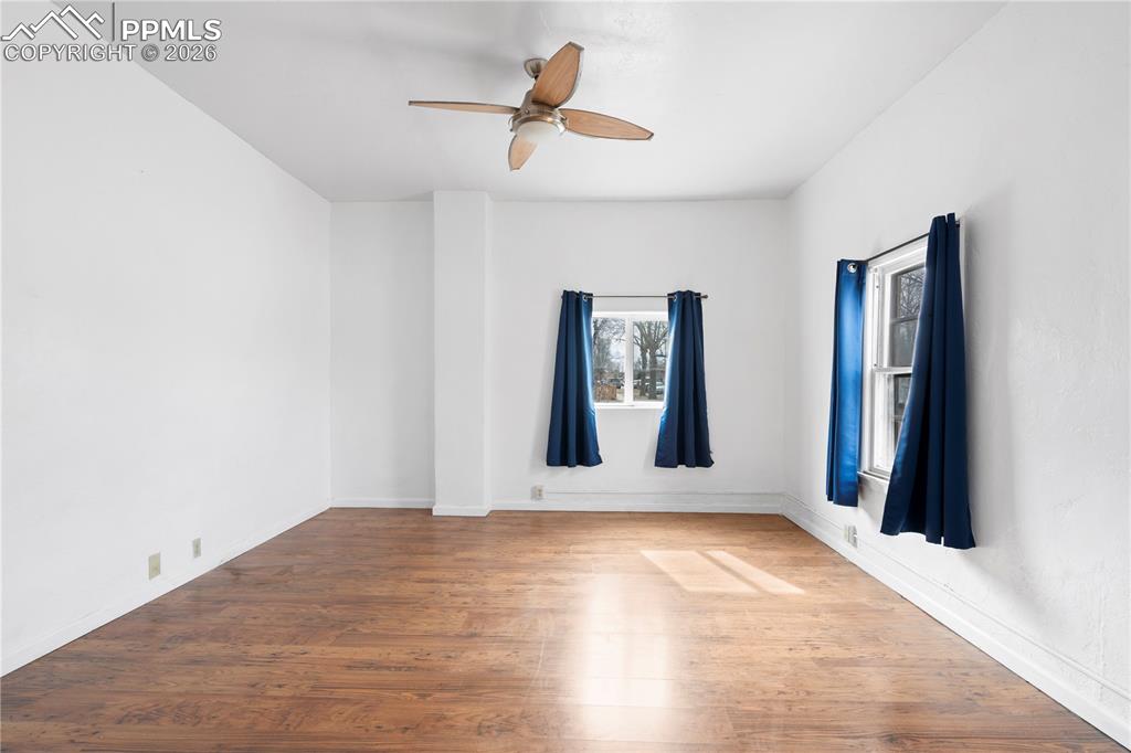 Unfurnished room featuring wood finished floors and a ceiling fan