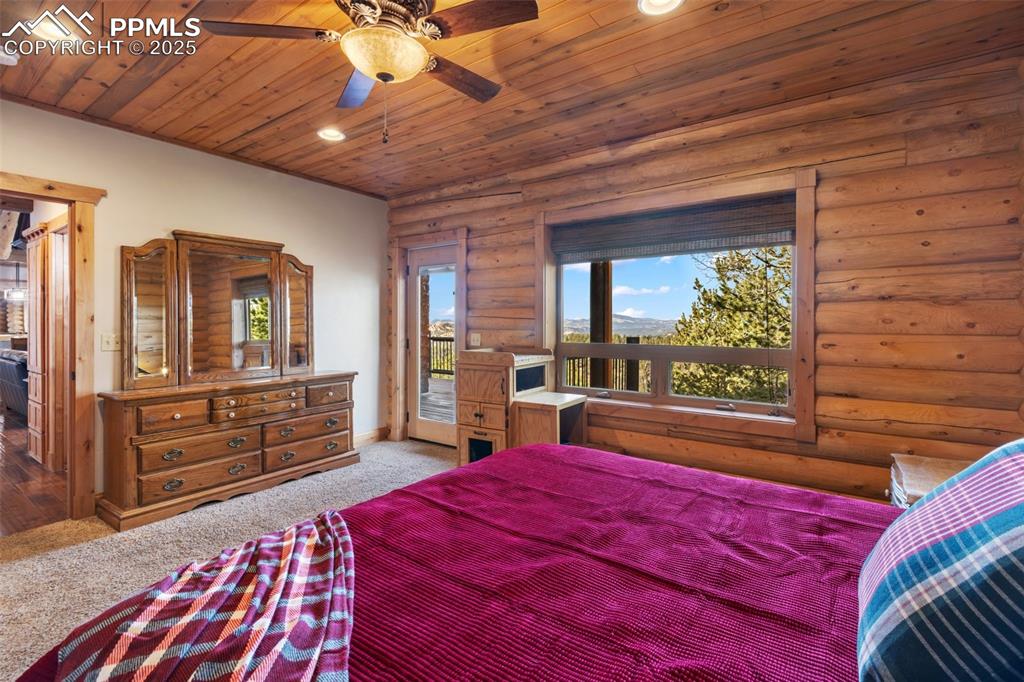 Carpeted bedroom with access to exterior, wood ceiling, recessed lighting, rustic walls, and ceiling fan