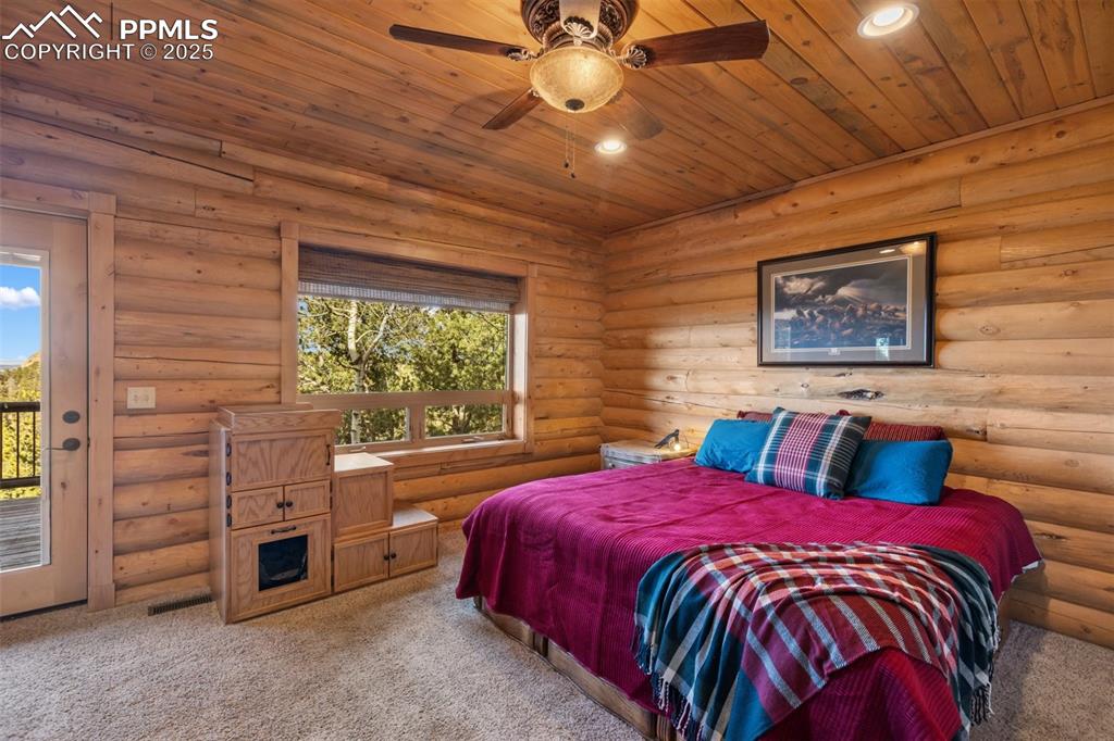 Bedroom with carpet floors, wood ceiling, access to outside, log walls, and recessed lighting