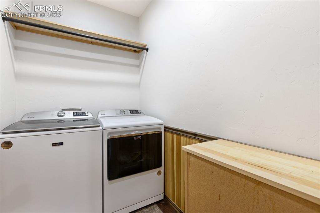 Laundry area featuring washing machine and dryer and a wainscoted wall