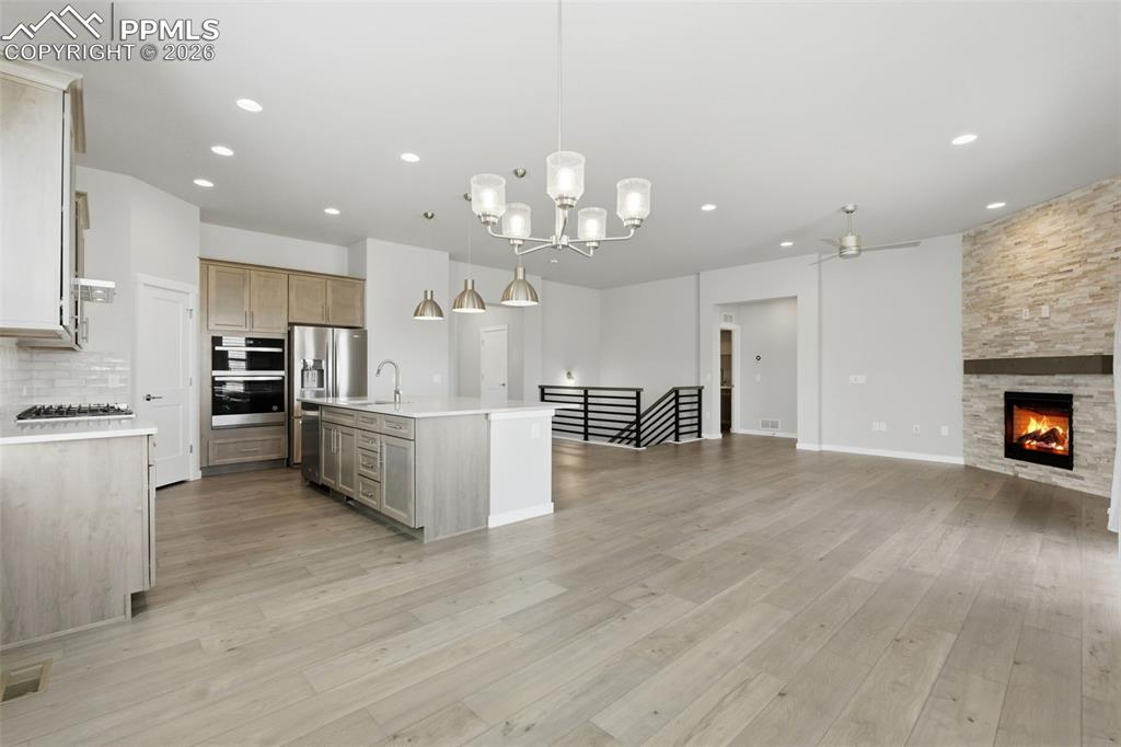 Kitchen featuring chandelier lighting, large island with pendant lights, and open dining area