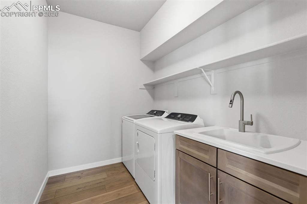 Spacious laundry room with upper cabinet storage, utility sink, and ample counter space