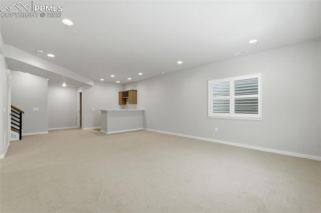 Open basement recreation area with egress window and recessed lighting - excellent finished space