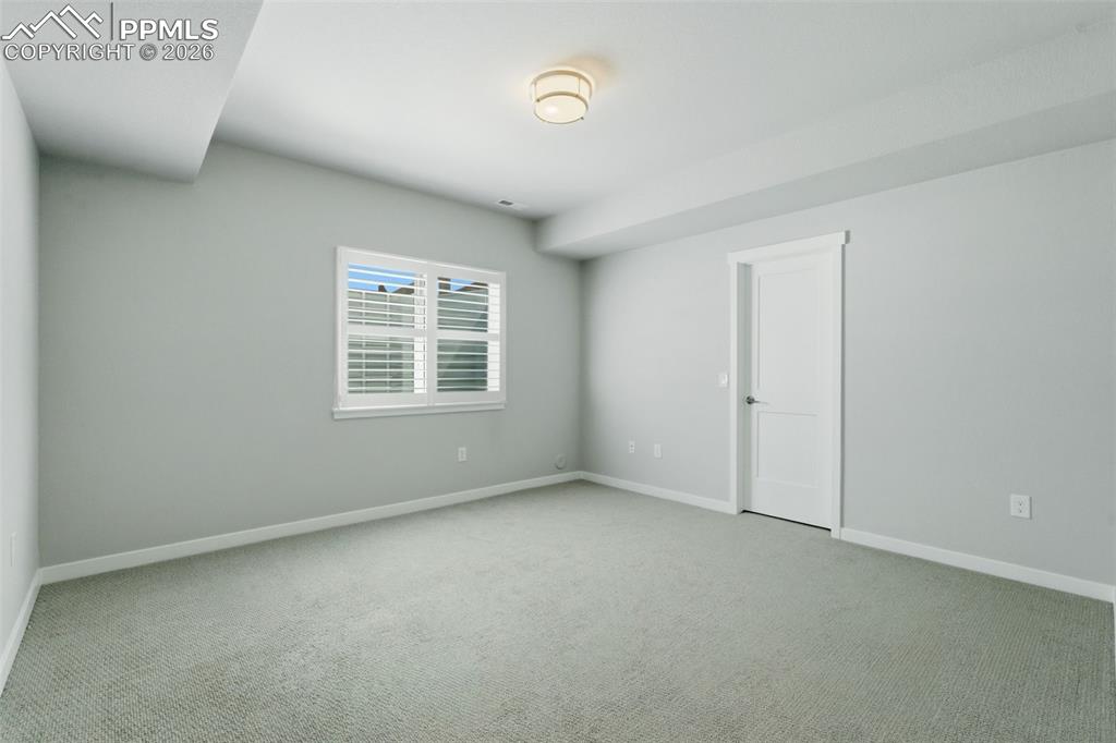 Basement flex room with egress window, carpet, and recessed lighting - great for office or guest space