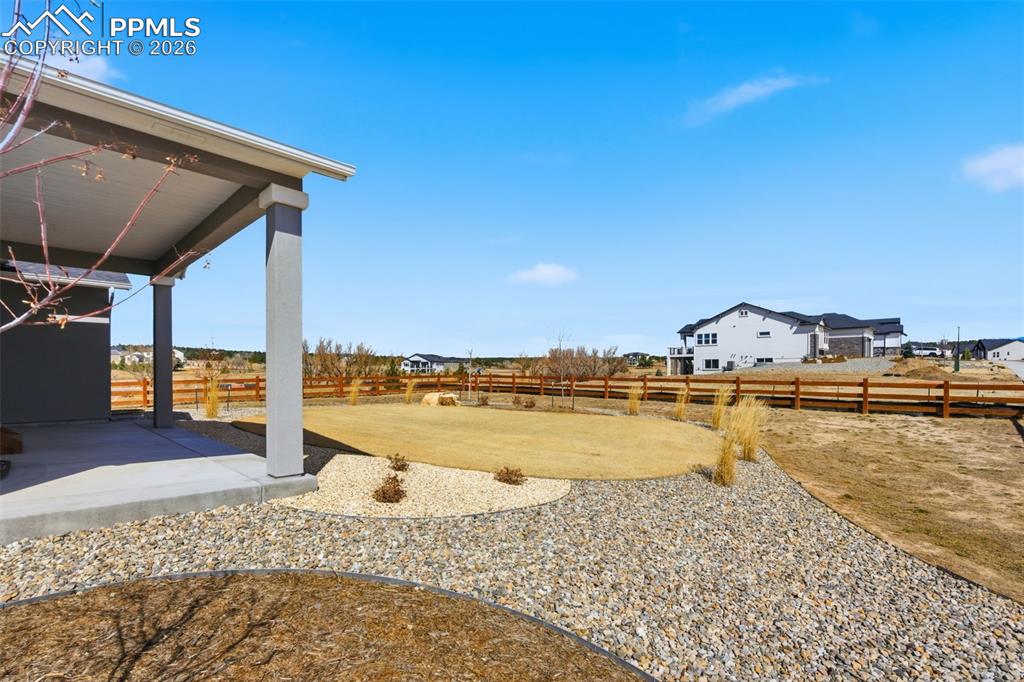 Beautiful backyard with spacious patio, mature landscaping, and mountain views