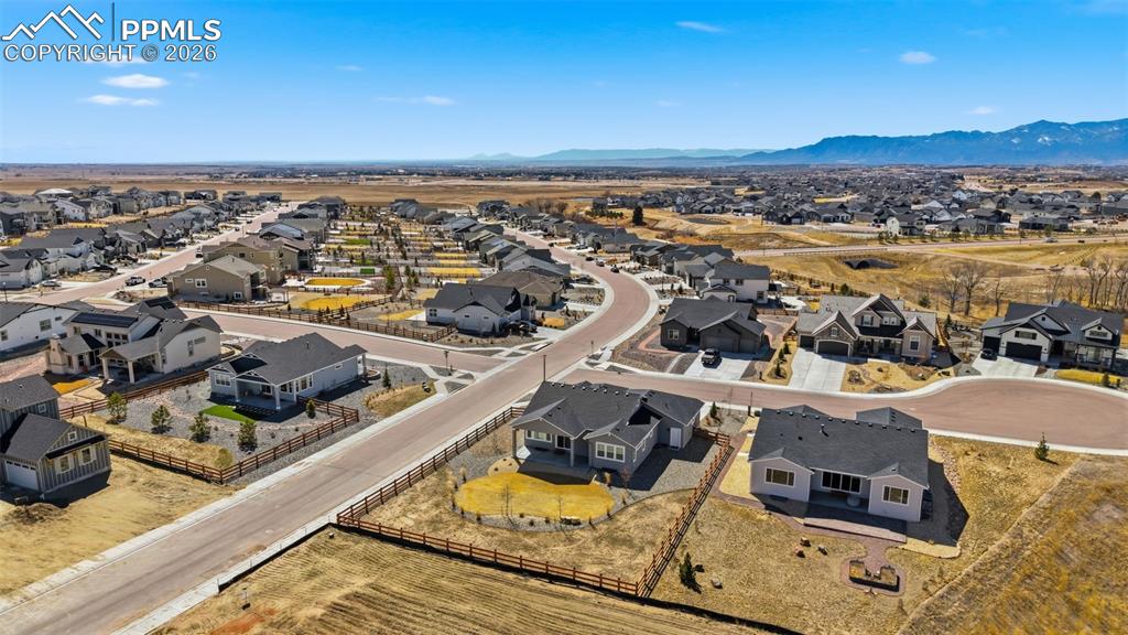 Aerial view of neighborhood streets, nearby properties, and the expansive Colorado Front Range mountains