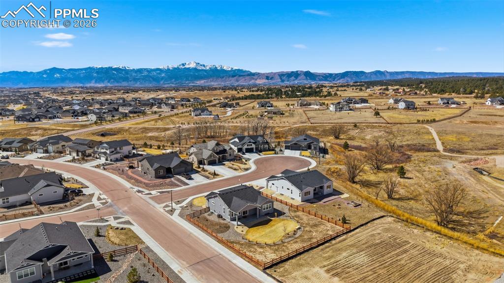 Aerial view capturing the home's proximity to open space, community features, and Pikes Peak views