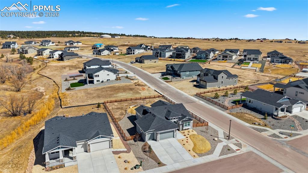 Elevated aerial shot showing home's position within the neighborhood, lot size, and mountain views