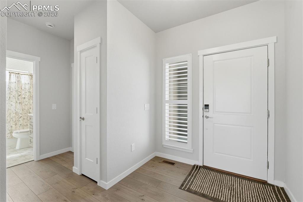 Bright and open foyer with luxury vinyl plank flooring and clean white walls