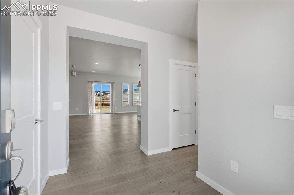 Open hallway with luxury vinyl plank flooring leading to main living areas